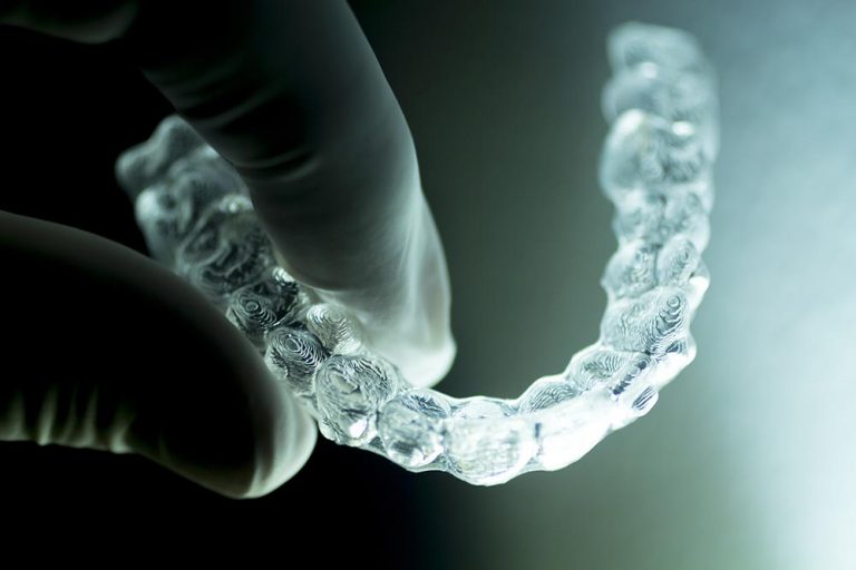 dentist holding a clear aligner tray