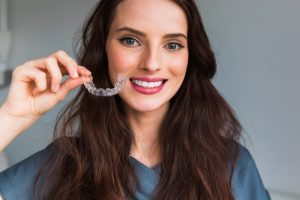 woman holding aligners