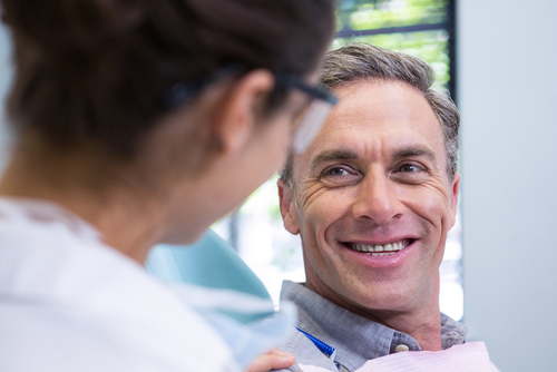 Closeup,Of,Happy,Patient,Looking,At,Dentist